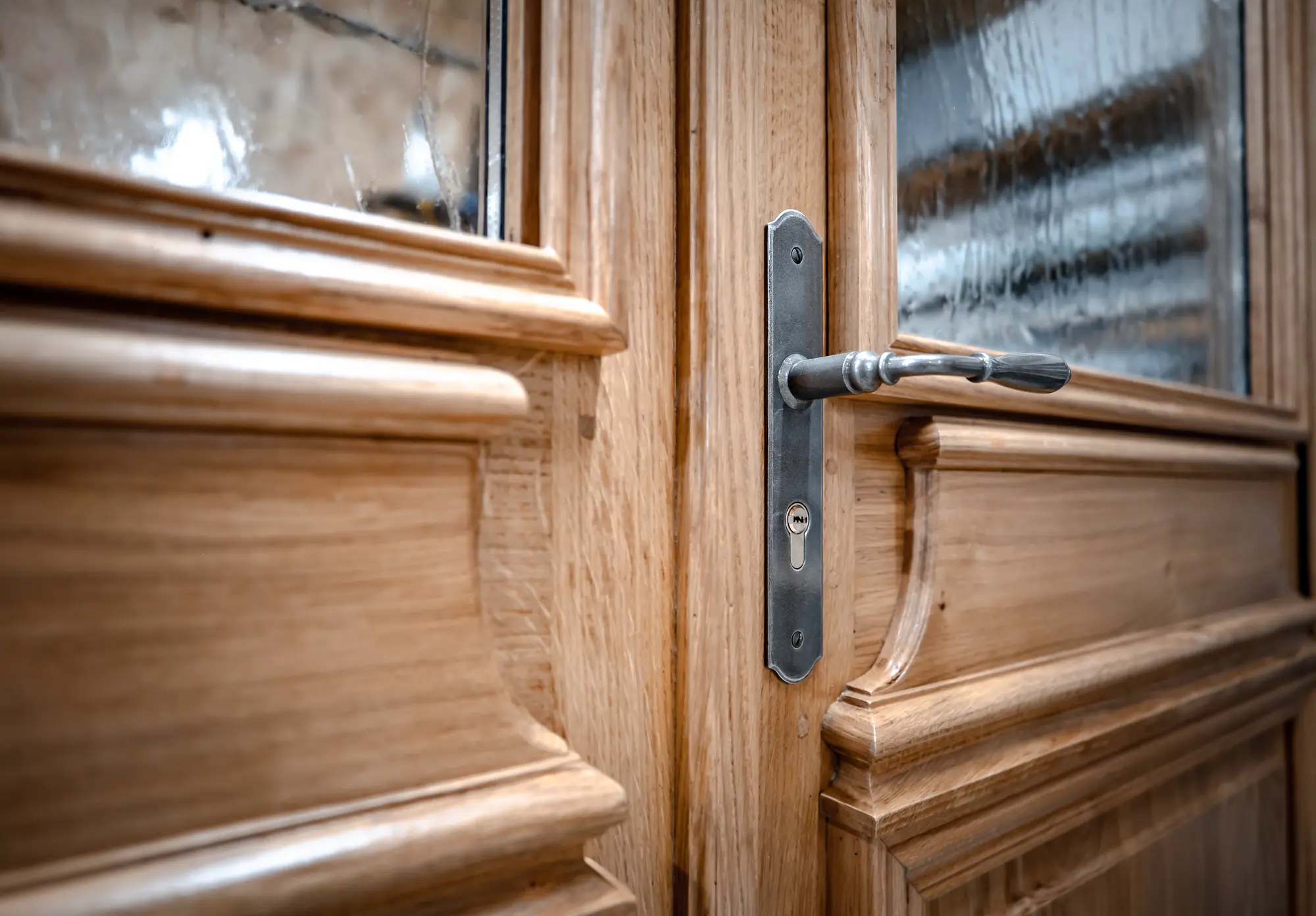Poignée et serrure posées sur une porte en chêne