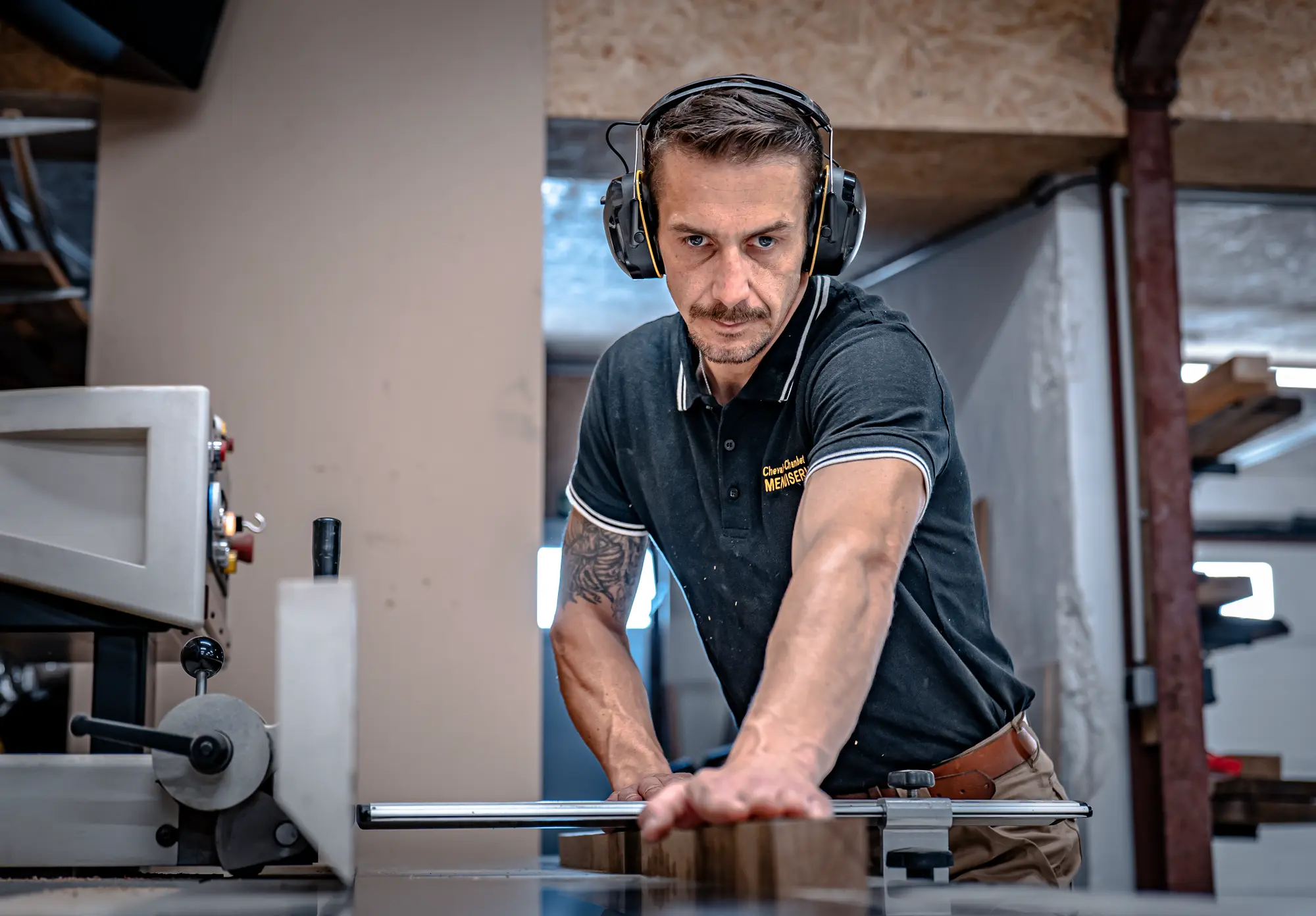 Menuisier de CCM au travail sur une pièce de bois à l’atelier